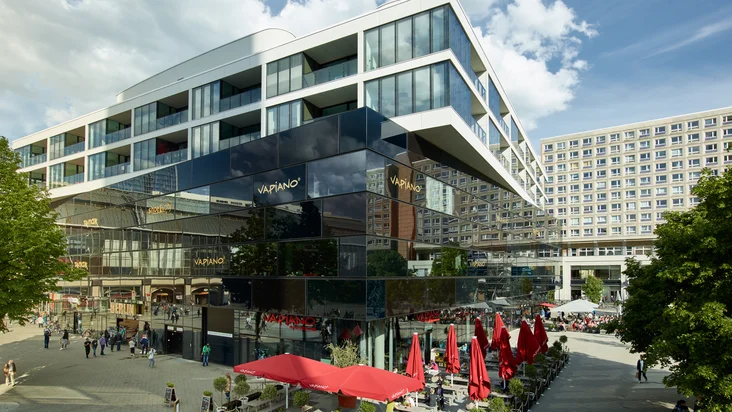 Ein großes Gebäude in der Fußgängerzone mit dem VAPIANO Berlin Alexanderplatz im Erdgeschoss.