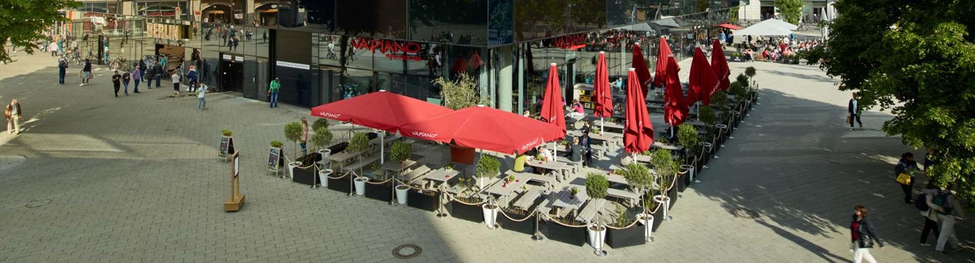 Ein großes Gebäude in der Fußgängerzone mit dem VAPIANO Berlin Alexanderplatz im Erdgeschoss.