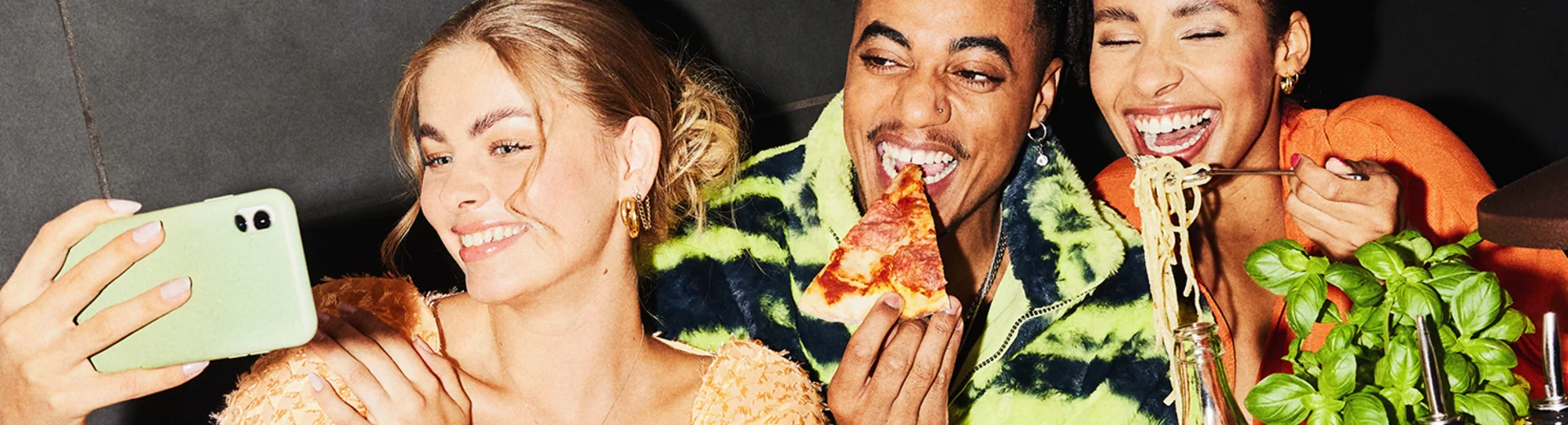 Drei Gäste machen ein Foto mit dem Handy im Restaurant.