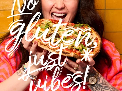 Eine Frau hält eine Pinsa und freut sich.