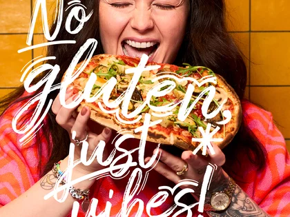 Eine Frau hält eine Pinsa und freut sich.