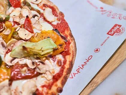 Die fertige Pinsa liegt auf einem Brettchen.