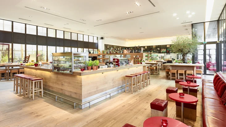 Innenaufnahme vom VAPIANO Bonn mit Tischen, Stühlen und einer Bar.